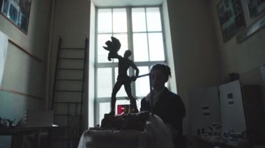 Bir genç kadın heykeltıraş antik bir adam figürü çamurdan yapılmış.