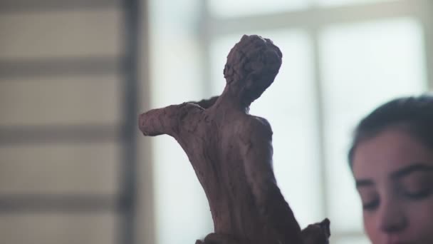 En figur av en gammel mann av leire foran kvinnelige skulptører. – stockvideo
