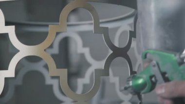Yakın çekim: metal dekoratif bir unsur altın tabanca sprey kullanarak boyama.