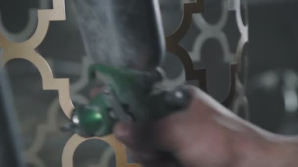Schilderij van een metalen decoratief element in goud met behulp van een spuitpistool. — Stockvideo