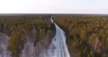 Bir helikopter kış ormanıyla çevrili kırsal bir çöl yol.