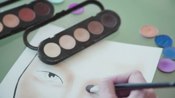 Visagist maakt make-up schets op de gezicht-grafiek — Stockvideo