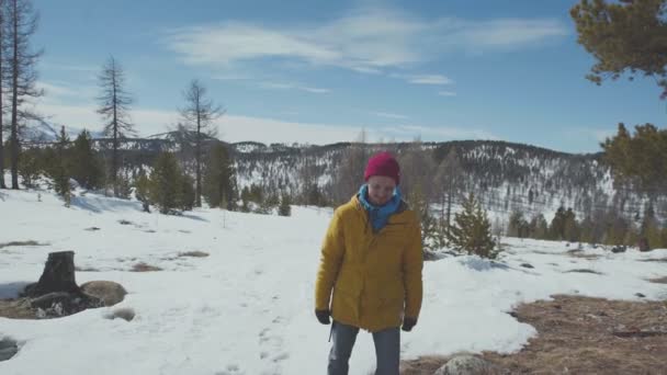 Een jonge man in een lichte jas bewondert de omliggende natuur — Stockvideo
