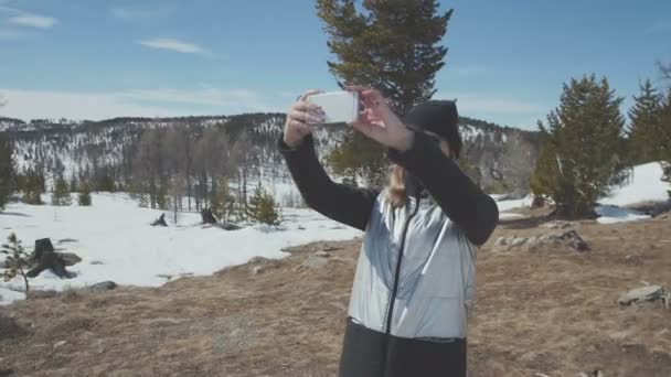 Lady hiker stående på toppen av berget som tar en bild av dalen. — Stockvideo