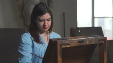 Gerçek bir karışıklık parlak çalışan kadın sanatçı studio resim yaktı