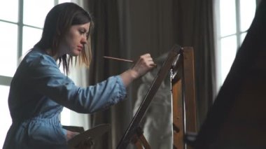 Bir kadın çiziyor. Yaratıcı bir meslek. Tuval.