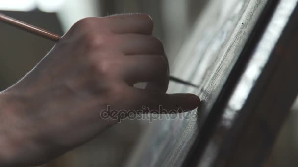 Hand des Künstlers, Pinsel und Leinwand auf der Staffelei. der Künstler bei der Arbeit — Stockvideo