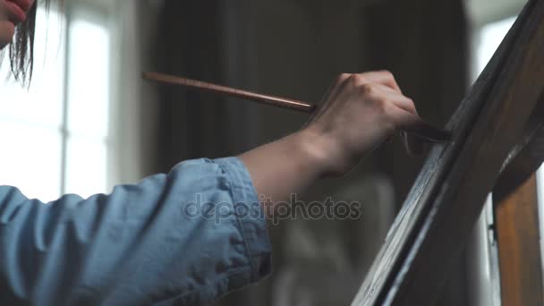 Muñeca: una artista femenina sostiene un pincel para dibujar, aplica pincelada — Vídeo de stock