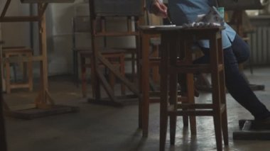 Ahşap bir taburede çizim araçları: boya, palet, brushe tüpler