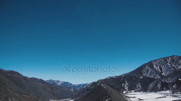Schneebedeckte Berggipfel unter blauem Himmel und weißen Wolken. — Stockvideo