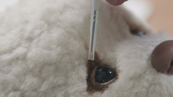 Meister malt Augen für einen Teddybär im altmodischen Stil. — Stockvideo