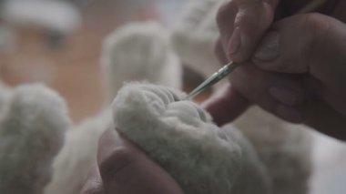 Oyuncak ayı yaratma süreci: bir oyuncak paws ana berabere.