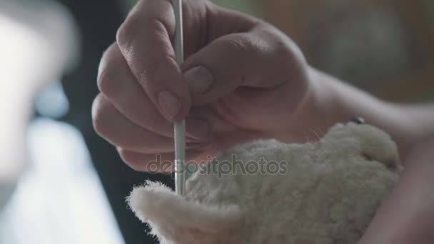 Process of creating a teddy bear: master paints the ears with a toy. — Stock Video