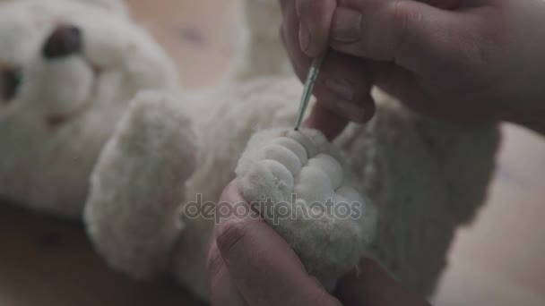 Escova fina nas mãos do artista para criar brinquedos macios. Urso de pelúcia — Vídeo de Stock