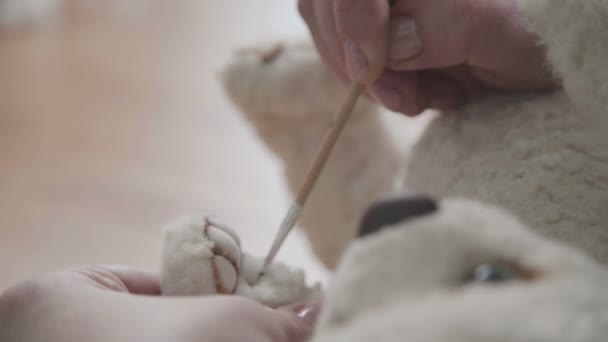 Handmade toy. Fine brush for drawing: paws of a soft toy. — Stock Video