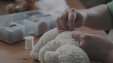 Bir oyuncak ayrıntılarını dikiş işlemi. Oyuncak ayı tamiri