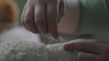 Eller bir oyuncak ayı dikmek. Yumuşak el yapımı oyuncaklar oluşturma.