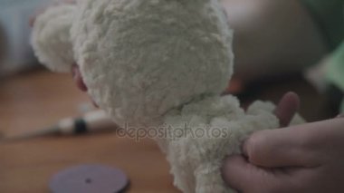 Bir peluş oyuncak ayrıntılarını dikiş. El yapımı oyuncak ayı