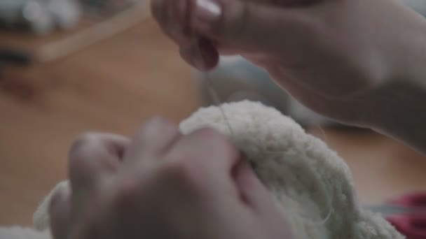 Concept: a favorite toy of children is a teddy bear. Needle and thread — Stock Video