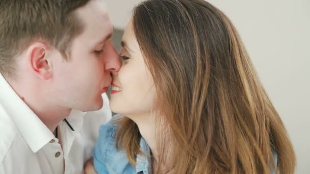 Hombre y una mujer enamorada se miran y se besan suavemente — Vídeo de stock