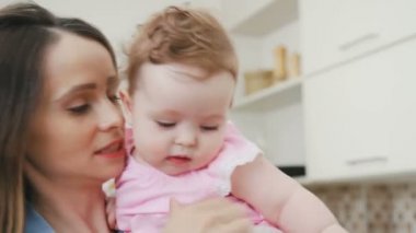 Anne kızı kollarında tutar ve onunla çalış.