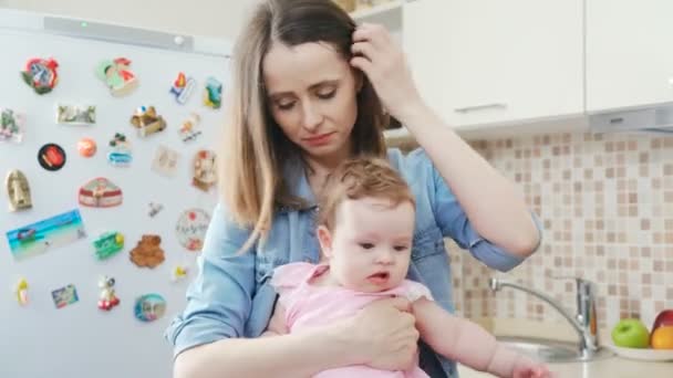 Красива брюнетка жінка зі своєю чарівною маленькою дочкою на кухні — стокове відео
