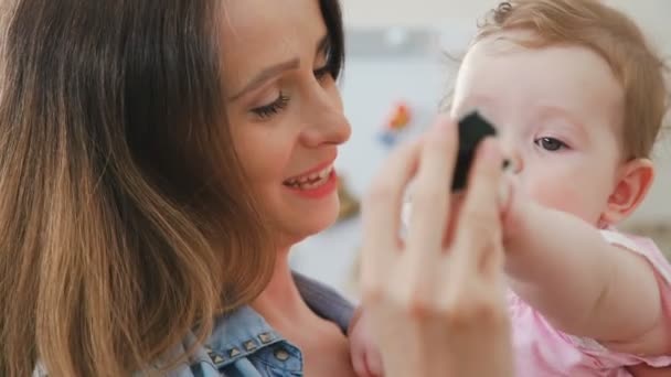 Young mother with a little baby in her arms. Beautiful brunette woman — Stock Video