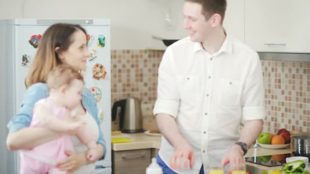 Ehemann bereitet Frühstück zu. Familie mit Baby in der Küche. — Stockvideo