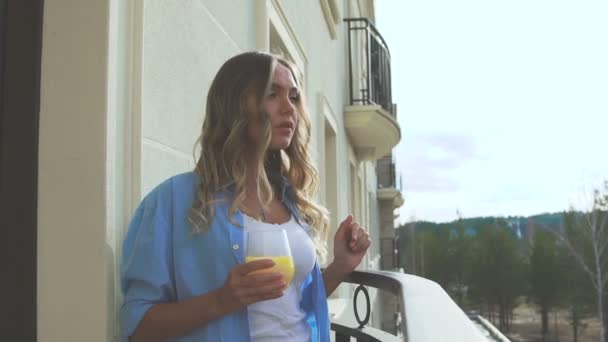 Romantische meisje op de veranda en drinken sap in de ochtend — Stockvideo