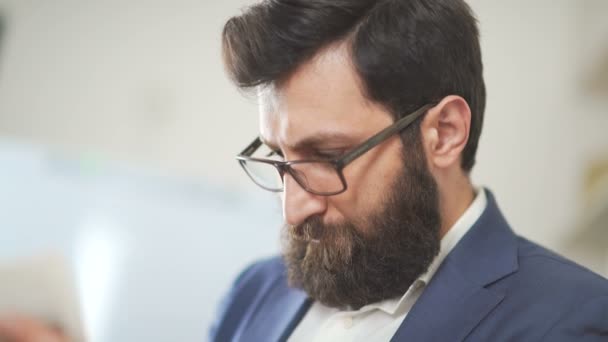 Atraktivní brutální muž s vousy na sobě sako používá mobilní telefon — Stock video