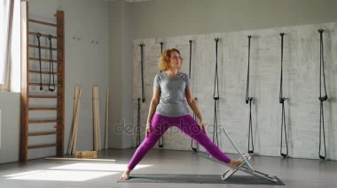 Parlak kadın 40-45 yaşında yoga parlak bir stüdyoda devreye girer.
