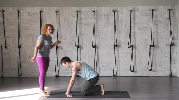 En kvinna utför asana under överinseende av en yogi hane — Stockvideo