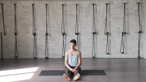 Ein junger Sportler praktiziert Yoga und wechselt Asanas. — Stockvideo