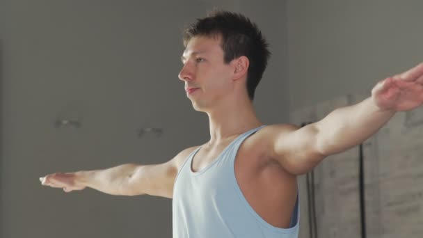 De yogi man staat in de krijgers pose en ziet er weg — Stockvideo