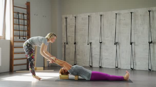 Femme mûre aux cheveux roux se trouve sur un tapis pour le yoga dans asana . — Video