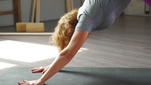 Adho Mukha Shvanasana. Vrouw van 35-40 jaar houdt zich bezig met yoga — Stockvideo