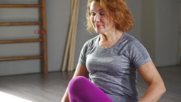 Een volwassen vrouw in lichte panty is betrokken bij de gymnastiek. Yoga volwassen — Stockvideo