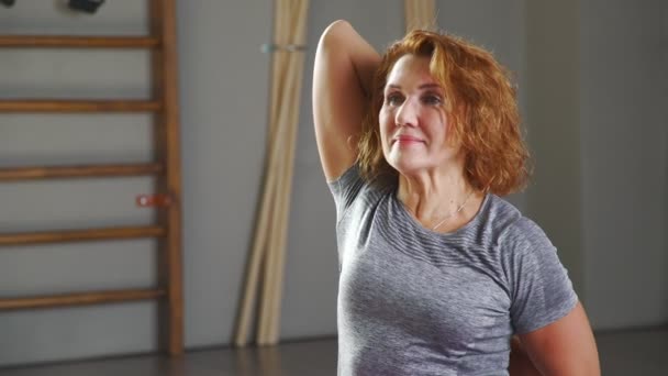 Una mujer de 35-40 años se dedica al yoga en un loft de yoga ligero . — Vídeo de stock