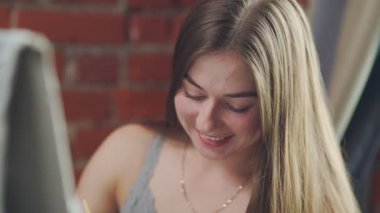 Uzun saçlı bir kadın sanatçı şövale oturan renkleri, karışımları