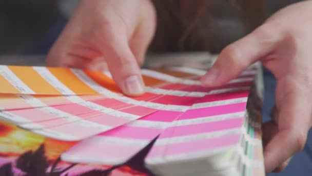 Frauenhände halten einen Fächerpantone - Farbauswahl für zukünftiges Produkt — Stockvideo