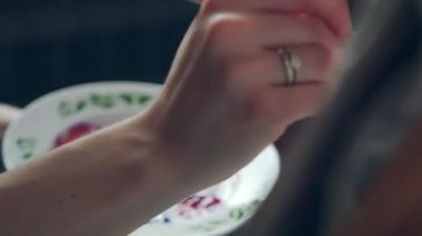 Sanatçı bir boya fırçası alır ve tuval üzerine çizer. Kadın sanatçı