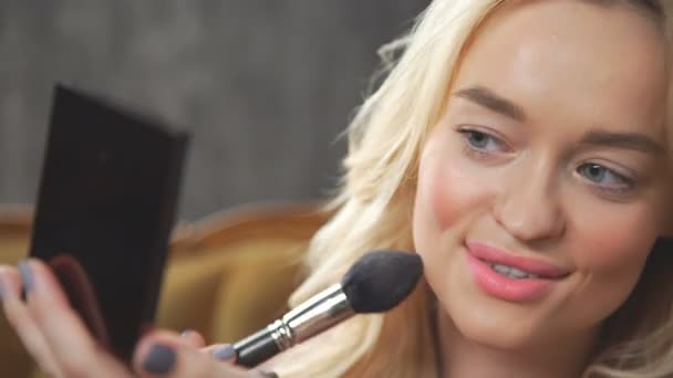 Ung vacker kvinna i soffan gör makeup — Stockvideo