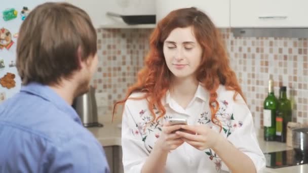 Zatoka dziewczyna z kręconymi włosami czerwony z telefonem, człowiek pije kawę. — Wideo stockowe