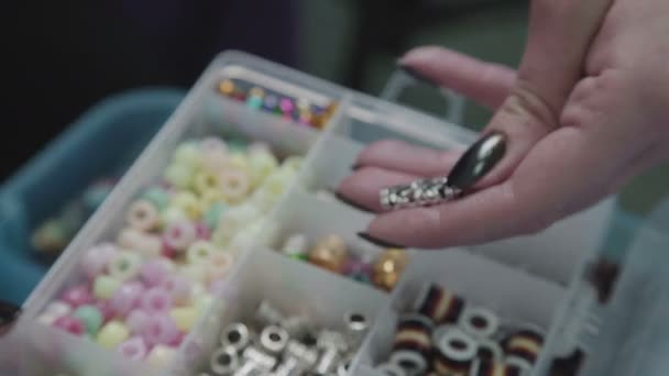 Fittings for decoration: beads, feathers, colored balls. Plastic case — Stock Video