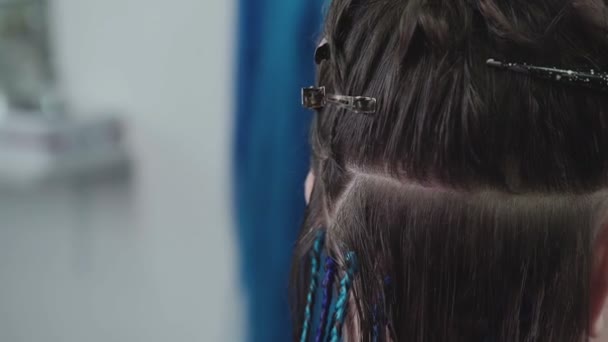Peluquero divide su cabello en separaciones y teje trenzas . — Vídeos de Stock