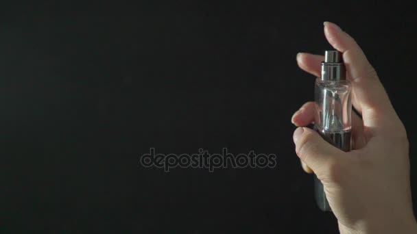 Female hands hold a bottle of perfume, spray it to feel fragrance. — Stock Video