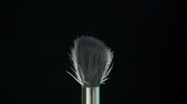 Kozmetik kozmetik toz siyah arka plan üzerine yayılan fırçayla.