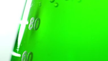 Bir işareti ile yeşil bir kimyasal sıvı ile bir cam şişeye birimde.