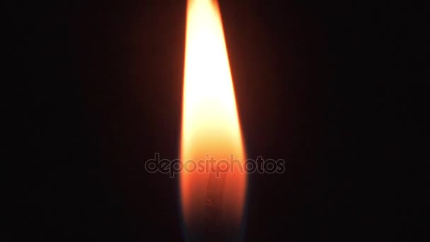 Lågan av ett stearinljus brinner på en mörk bakgrund. Brinnande ljus — Stockvideo