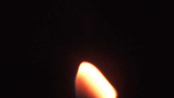 La fiamma di una candela si muove su sfondo nero. Luce da una fiamma di candela — Video Stock